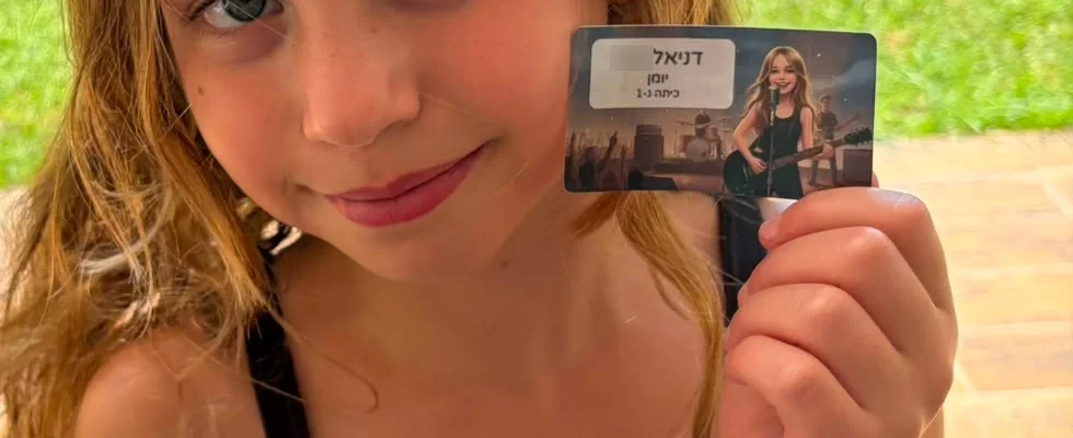 ילדה מחזיקה מדבקת שם מודפסת עם איור שלה כזמרת רוק על הבמה